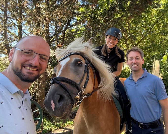 Drei Menschen und ein Haflinger vor Bäumen: Christoph Mader, Matthias Einzinger und eine Reiterin im Sattel